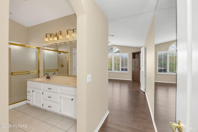 bathroom featuring vaulted ceiling, wood-type flooring, vanity, and a shower with shower door