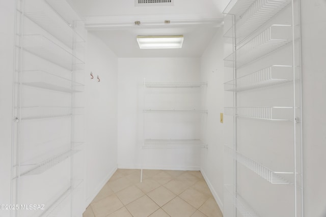 spacious closet with light tile patterned floors