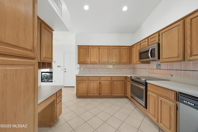 kitchen with tasteful backsplash, stainless steel appliances, and light tile patterned floors