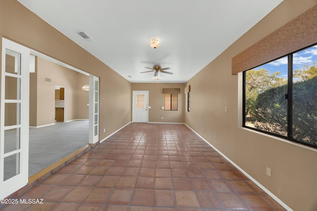 tiled spare room with ceiling fan