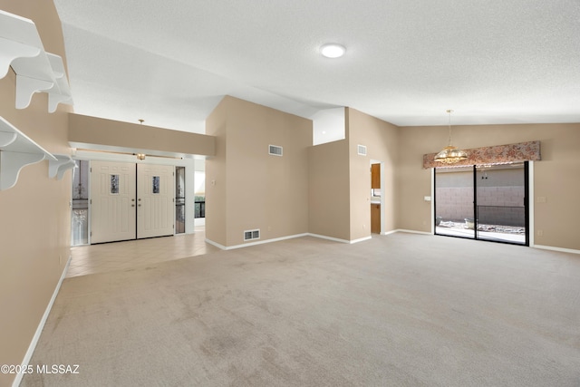 unfurnished living room featuring high vaulted ceiling, light colored carpet, and a textured ceiling