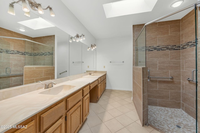 bathroom featuring an enclosed shower, vanity, a skylight, and tile patterned floors