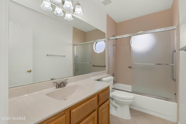 full bathroom featuring tile patterned flooring, vanity, bath / shower combo with glass door, and toilet