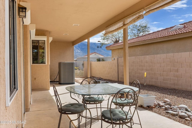 view of patio / terrace with a mountain view and central AC unit