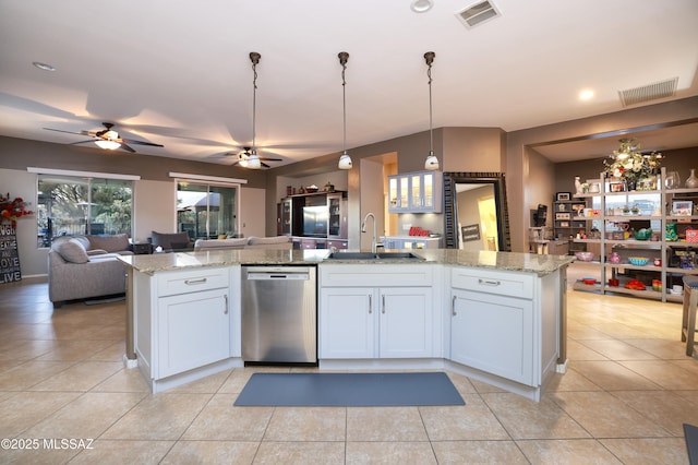 kitchen with a kitchen island with sink, sink, stainless steel dishwasher, and white cabinets