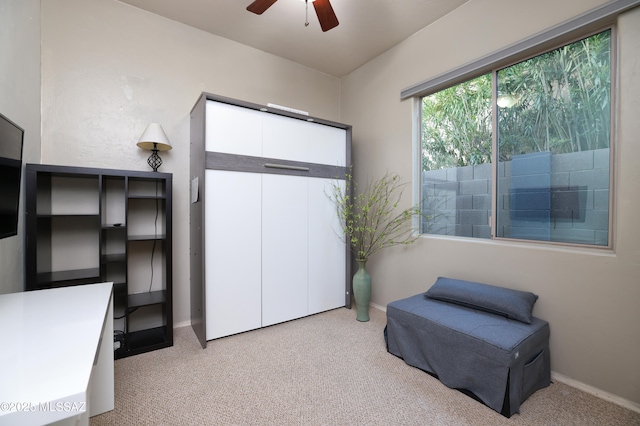 sitting room with ceiling fan and light colored carpet