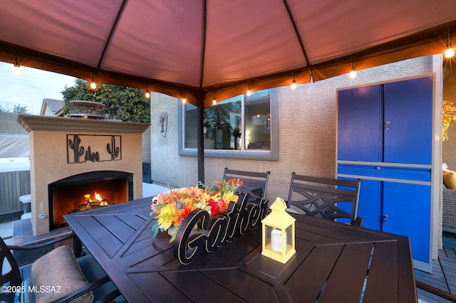 deck featuring a gazebo and exterior fireplace