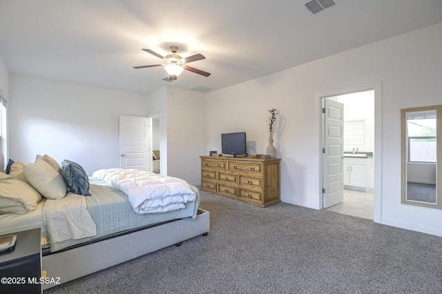 bedroom featuring light carpet, sink, ceiling fan, and ensuite bathroom