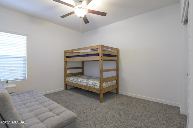 bedroom with multiple windows, ceiling fan, and dark colored carpet