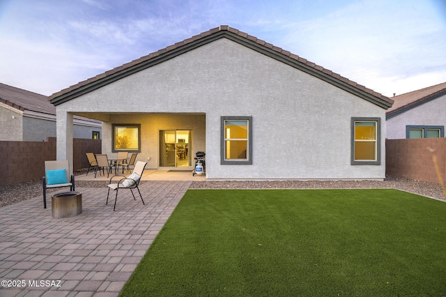 back of house with a lawn and a patio