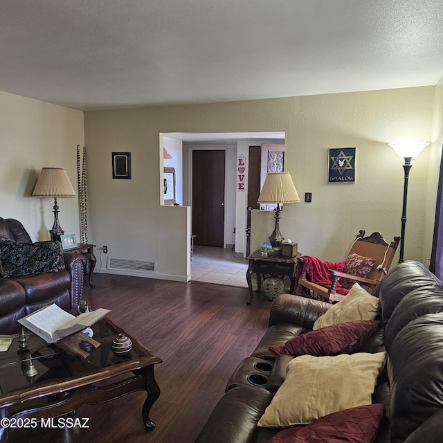 living room featuring wood-type flooring and a textured ceiling