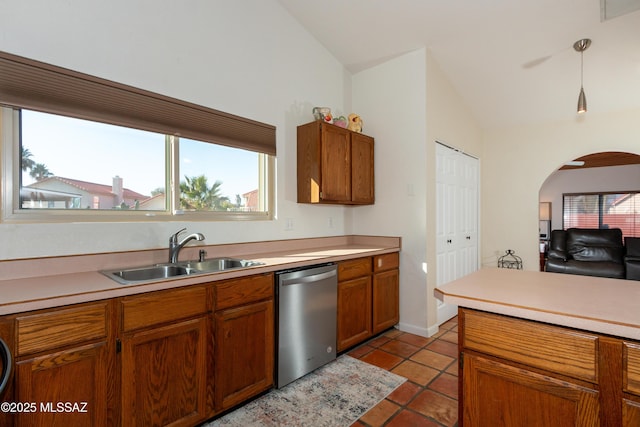 kitchen with lofted ceiling, sink, dishwasher, light tile patterned flooring, and decorative light fixtures