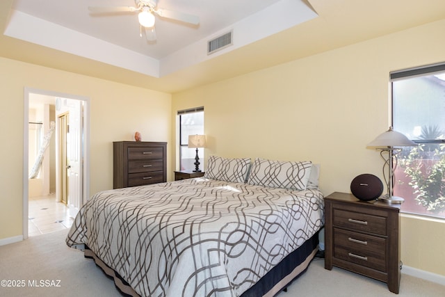 carpeted bedroom with a tray ceiling