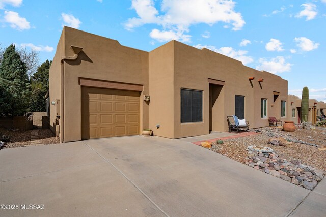 pueblo revival-style home with a garage