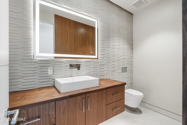 bathroom with vanity, tile patterned floors, backsplash, and toilet