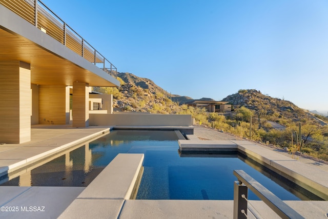 view of pool with a mountain view and a patio area