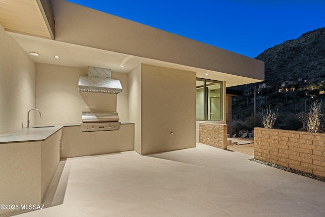 view of patio featuring sink, grilling area, a mountain view, and an outdoor kitchen