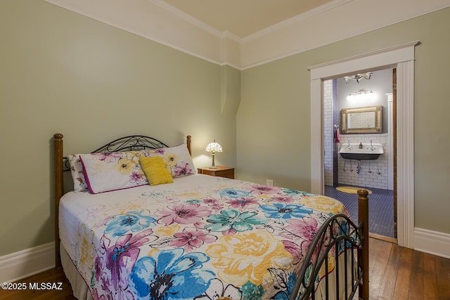 bedroom with dark hardwood / wood-style flooring, sink, crown molding, and ensuite bathroom