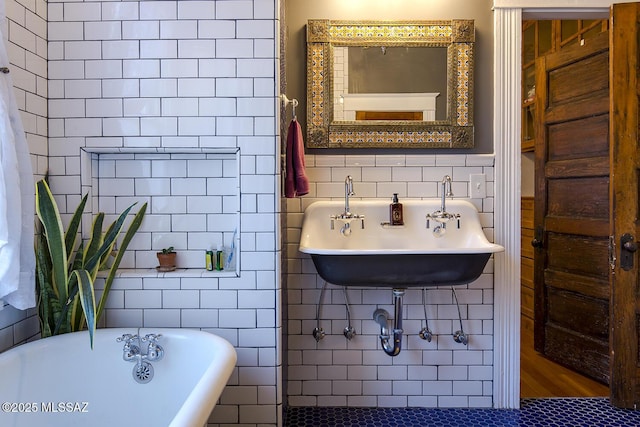 bathroom with tile walls, sink, and a tub to relax in