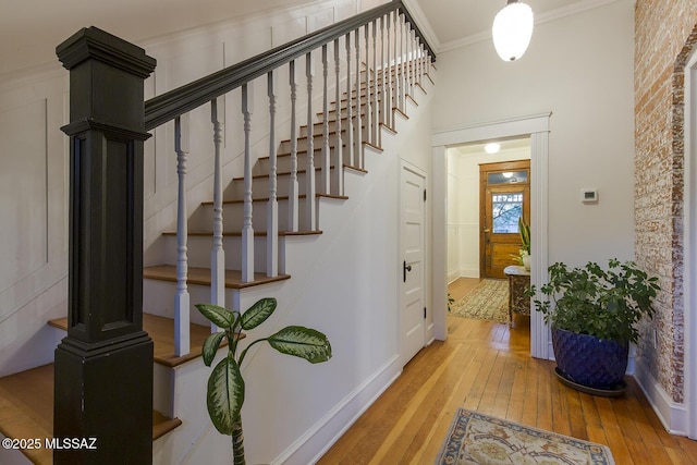 staircase featuring hardwood / wood-style flooring and ornamental molding