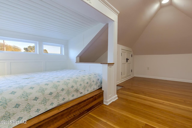 bedroom with vaulted ceiling and light hardwood / wood-style floors