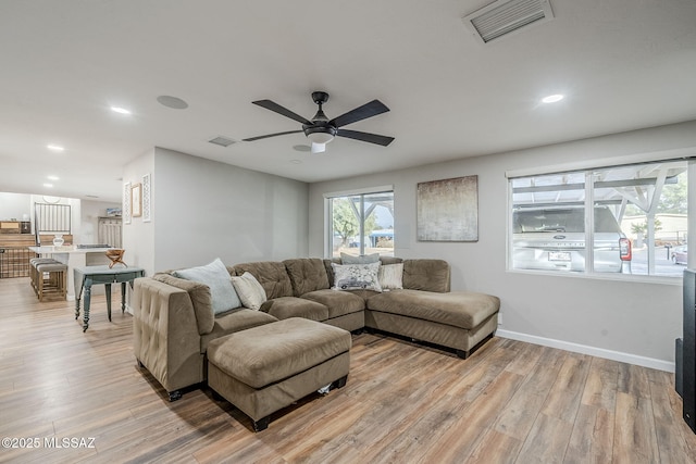 living room with light hardwood / wood-style flooring and ceiling fan