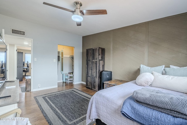 bedroom featuring hardwood / wood-style flooring, ceiling fan, and a spacious closet