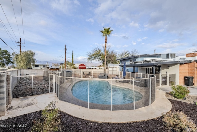 view of pool with a storage unit and a patio area