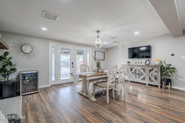 dining room with hardwood / wood-style flooring, beverage cooler, and french doors