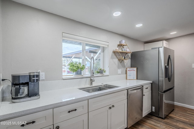 kitchen featuring sink, white cabinetry, light stone counters, appliances with stainless steel finishes, and dark hardwood / wood-style floors