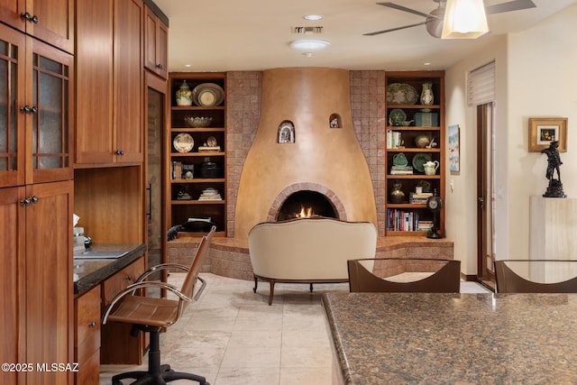 office featuring ceiling fan, a fireplace, and built in features