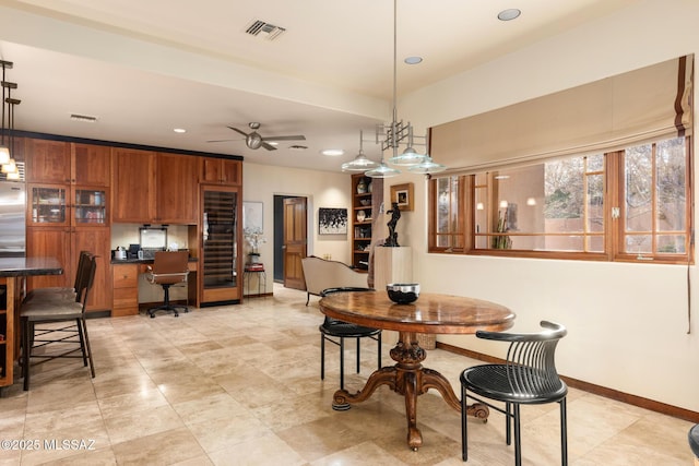 dining area with built in desk and ceiling fan