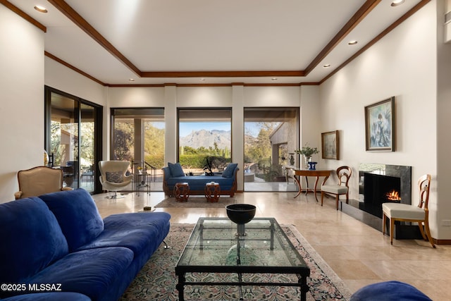 living room featuring a raised ceiling, ornamental molding, and a towering ceiling