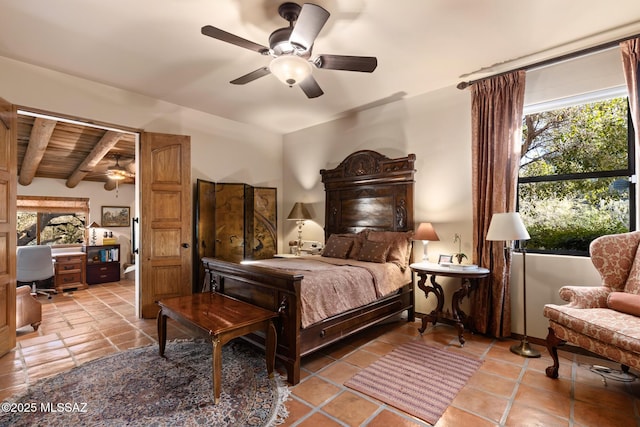 bedroom with ceiling fan and beam ceiling