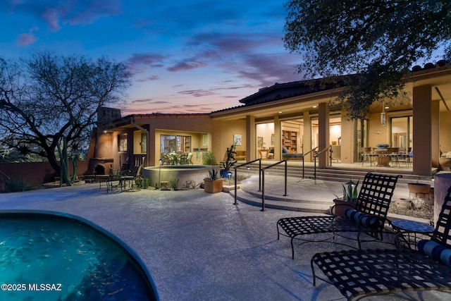 back house at dusk with a patio