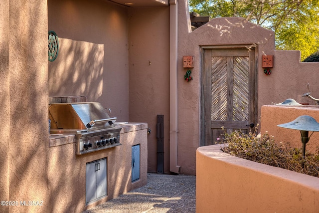 view of patio with area for grilling and a grill