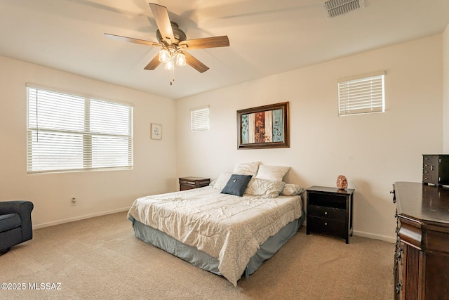 carpeted bedroom featuring baseboards, a ceiling fan, and visible vents