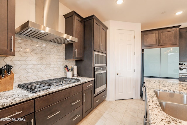 kitchen featuring ventilation hood, light stone countertops, and appliances with stainless steel finishes