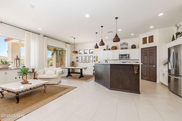 kitchen featuring stainless steel appliances, white cabinetry, and a center island