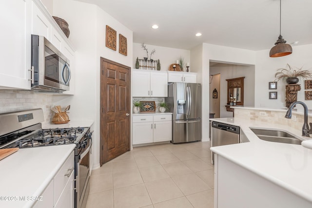 kitchen featuring hanging light fixtures, white cabinetry, appliances with stainless steel finishes, and sink