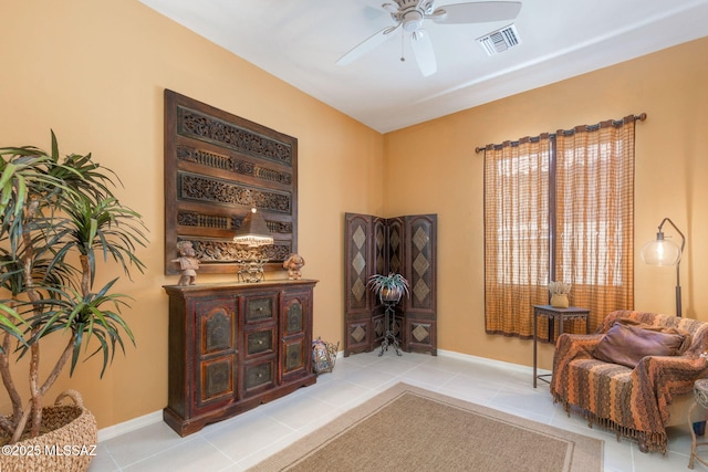 living area with light tile patterned floors and ceiling fan