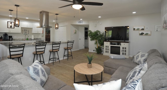 living room with ceiling fan and light wood-type flooring