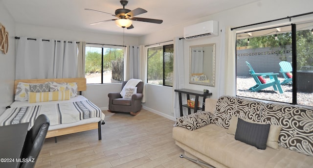 bedroom with an AC wall unit, light wood-type flooring, and ceiling fan