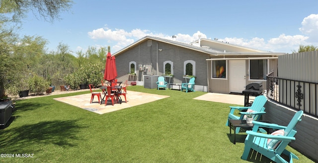 rear view of house featuring a patio area and a lawn