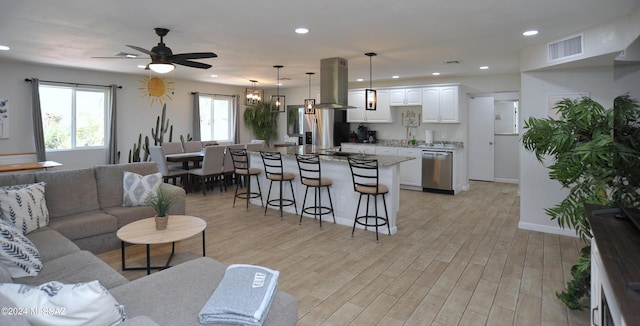 living room with light hardwood / wood-style floors and ceiling fan