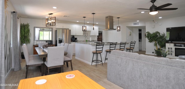 living room featuring sink and ceiling fan with notable chandelier