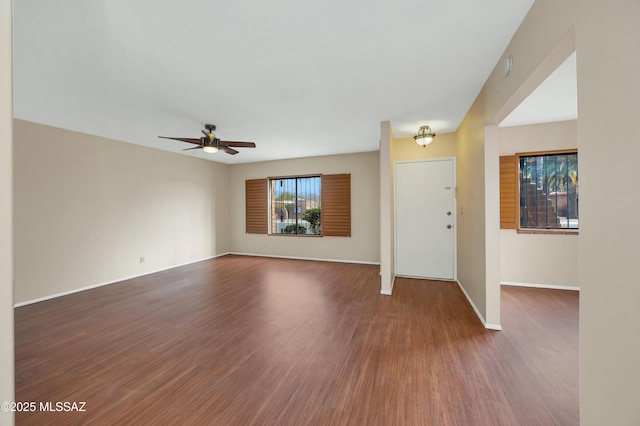 unfurnished living room featuring ceiling fan and dark hardwood / wood-style flooring