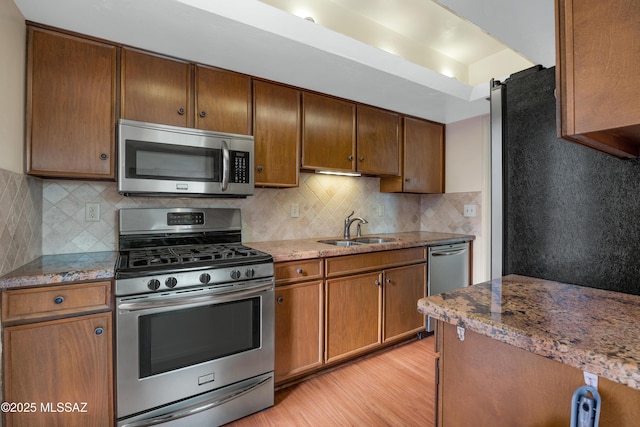 kitchen featuring stone countertops, appliances with stainless steel finishes, and sink