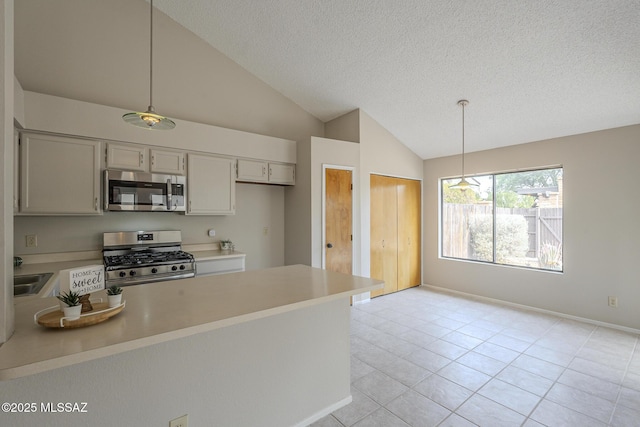 kitchen featuring hanging light fixtures, appliances with stainless steel finishes, lofted ceiling, and a textured ceiling