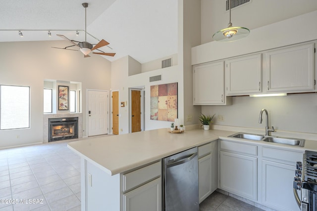 kitchen with sink, appliances with stainless steel finishes, hanging light fixtures, white cabinets, and kitchen peninsula